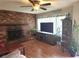 Cozy living room with a brick fireplace, ceiling fan, and wood laminate flooring at 1202 Deidrich Ct, Eustis, FL 32726