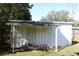 Exterior view of a shed with an open-air overhang for storage, adjacent to a grassy lawn at 1202 Deidrich Ct, Eustis, FL 32726