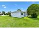 Home's well-maintained backyard with green lawn and mature trees at 1309 Lester Dr, Lady Lake, FL 32159