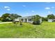 A bright home with a manicured front lawn with green grass and shrubs around the house at 1309 Lester Dr, Lady Lake, FL 32159