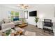 Bright living room with a large sofa, modern entertainment setup, and ample seating at 1309 Lester Dr, Lady Lake, FL 32159