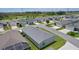 Birds eye shot of residential homes, manicured lawns, and shady trees with a clear blue sky overhead at 1478 Erika Pl, The Villages, FL 32163