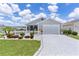 Beautiful home features an attached garage, manicured lawn, and decorative white picket fence surrounding a landscaped garden at 1478 Erika Pl, The Villages, FL 32163