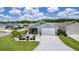 Charming home featuring an attached garage, manicured lawn, and decorative white picket fence surrounding a landscaped garden at 1478 Erika Pl, The Villages, FL 32163