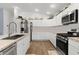 Well-lit kitchen features stainless steel appliances, granite countertops, and stylish white cabinetry at 1478 Erika Pl, The Villages, FL 32163