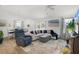 Bright living room boasts an open floor plan with modern furnishings and coastal-themed decor with a ceiling fan at 1478 Erika Pl, The Villages, FL 32163
