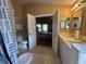 En suite bathroom featuring double sinks, mirrors, and an open doorway into the primary bedroom at 15509 Markham Dr, Clermont, FL 34714