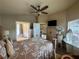 Bedroom features a ceiling fan, TV, and a view into the en-suite bathroom and living area at 15509 Markham Dr, Clermont, FL 34714