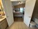 View from the bathroom into the main bedroom, which features natural light, a ceiling fan, and wood-look flooring at 15509 Markham Dr, Clermont, FL 34714