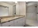Modern bathroom featuring a granite vanity, a large mirror, and a walk-in shower at 1603 Woodward St # 18, Orlando, FL 32803