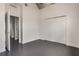 Well-lit bedroom featuring concrete floors, a large closet, and multiple doorways at 1603 Woodward St # 18, Orlando, FL 32803