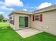 Cozy back patio with sliding glass door access, and charming red shutters enhancing the exterior at 1948 Harston Trl, The Villages, FL 32162