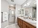 Bathroom with double sink vanity, shower, and tiled floors offers a clean and modern design at 1948 Harston Trl, The Villages, FL 32162