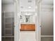 Hallway view of shared bathroom featuring dual sinks, tile floors, and ample closet space at 1948 Harston Trl, The Villages, FL 32162