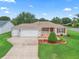 Charming single-story home featuring a two-car garage, well-manicured lawn and colorful landscaping at 1948 Harston Trl, The Villages, FL 32162