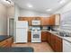 Functional kitchen features wood cabinets, white appliances, and ample counter space at 1948 Harston Trl, The Villages, FL 32162