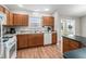 Open kitchen area boasts wood cabinets, a white dishwasher and a view into the dining area at 1948 Harston Trl, The Villages, FL 32162