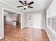 Bright living room with hardwood floors and neutral paint provides a large window and fan fixture at 1948 Harston Trl, The Villages, FL 32162