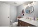 Bathroom with a single sink vanity and a round mirror at 2108 Dogwood Cir, Mount Dora, FL 32757