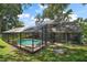 Rear view of house showcasing the screened-in pool and the surrounding backyard at 2108 Dogwood Cir, Mount Dora, FL 32757