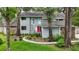 Charming two-story home with gray siding, stone accents, a landscaped yard, and a vibrant red front door at 2108 Dogwood Cir, Mount Dora, FL 32757