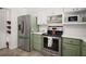 Well-equipped kitchen with green cabinetry, stainless steel appliances, and ample countertop space at 2108 Dogwood Cir, Mount Dora, FL 32757