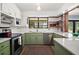 Updated kitchen with green cabinetry, modern countertops, stainless steel appliances, and stylish fixtures at 2108 Dogwood Cir, Mount Dora, FL 32757