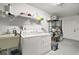 Well-lit laundry room with washer, dryer, sink, storage shelves, and a door at 2108 Dogwood Cir, Mount Dora, FL 32757