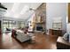 Spacious living room with a stone fireplace, hardwood floors, and sliding doors to the outdoor pool area at 2108 Dogwood Cir, Mount Dora, FL 32757