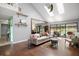 Bright living room with hardwood floors, vaulted ceilings, skylights, and sliding doors to the pool area at 2108 Dogwood Cir, Mount Dora, FL 32757