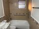 Updated bathroom showcasing modern tile, fixtures, grab bars, and window above the tub at 228 Cannon Way, Casselberry, FL 32707