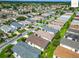 A beautiful aerial view features a suburban neighborhood with mature trees and uniform landscaping at 2311 Pine Ridge St, The Villages, FL 32162
