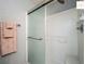 Bathroom features a shower with glass doors, white tile, and a towel rack at 2311 Pine Ridge St, The Villages, FL 32162