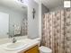 Bright bathroom featuring a modern vanity, decorative shower curtain, and a well-lit mirror at 2311 Pine Ridge St, The Villages, FL 32162