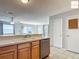 The kitchen features a stainless steel dishwasher, wood cabinets, and opens to the adjoining living area at 2311 Pine Ridge St, The Villages, FL 32162