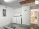 Functional laundry room features washer and dryer, storage shelving, and easy access from the garage at 2311 Pine Ridge St, The Villages, FL 32162
