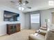 Cozy living room with a large screen television, comfortable furniture, and natural light at 2311 Pine Ridge St, The Villages, FL 32162