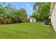 Spacious backyard with lush green grass, a storage shed, and privacy fence at 2311 Vincent Rd, Orlando, FL 32817