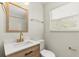 Beautiful bathroom with wooden vanity, gold hardware, and a quartz countertop at 2311 Vincent Rd, Orlando, FL 32817