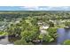 Expansive aerial view of lush community with lake, mature trees, and well-maintained homes at 2512 Baywater Rd, Tavares, FL 32778