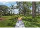 Beautiful backyard with a pathway, lush greenery, and mature trees at 2512 Baywater Rd, Tavares, FL 32778