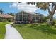 Well-maintained backyard with a screened porch, beautiful landscaping, and a winding pathway at 2512 Baywater Rd, Tavares, FL 32778