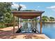 Covered boathouse on a wooden dock with boat lift overlooking the canal and surrounding waterfront homes at 2512 Baywater Rd, Tavares, FL 32778