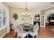 Dining room with hardwood floors, chandelier, and view to a bar, piano and into other spaces at 2512 Baywater Rd, Tavares, FL 32778