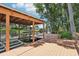 View from the wooden dock with covered boathouse, metal boat lift, canal views, and lush trees at 2512 Baywater Rd, Tavares, FL 32778