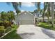 Well-maintained home showcasing a driveway and lush tropical landscaping at 2512 Baywater Rd, Tavares, FL 32778