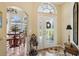 Welcoming foyer with decorative glass door, tile flooring, and arched doorway to the dining area at 2512 Baywater Rd, Tavares, FL 32778