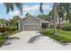 Charming home with a two-car garage, mature palm trees, and a well-manicured lawn at 2512 Baywater Rd, Tavares, FL 32778