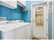 Well-lit laundry room with modern washer, dryer, and convenient access to the garage at 2512 Baywater Rd, Tavares, FL 32778