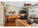 Well-lit living room with hardwood floors, built-in desk, and a ceiling fan at 2512 Baywater Rd, Tavares, FL 32778
